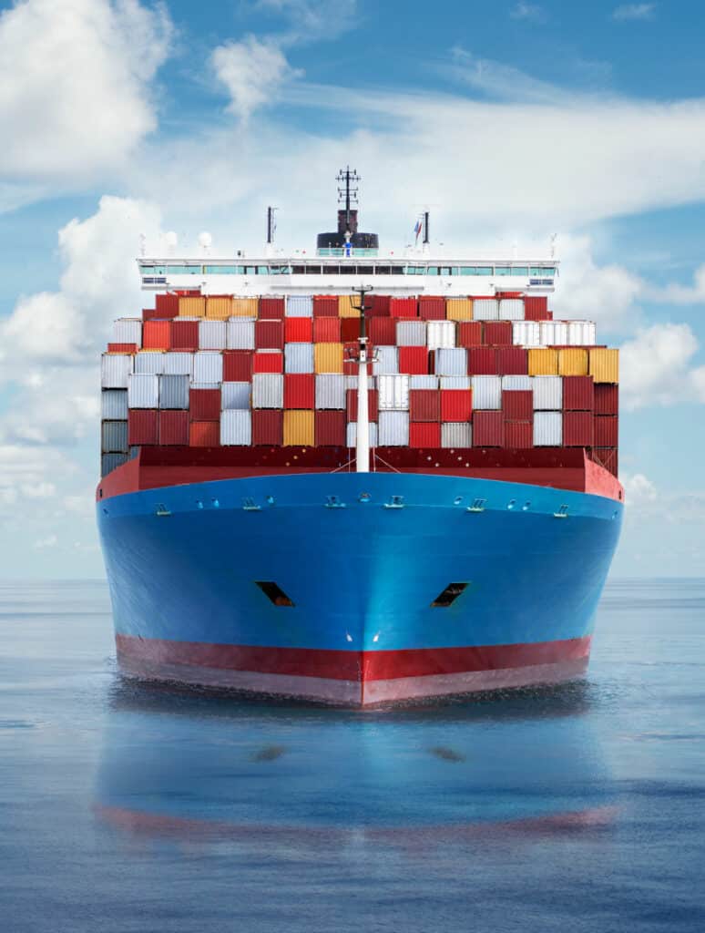 Front view from bow of a large blue shipping container ship.
