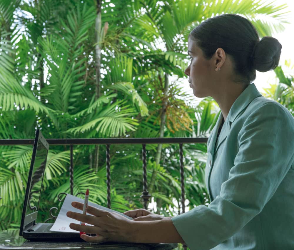 woman on her laptop with exotic view